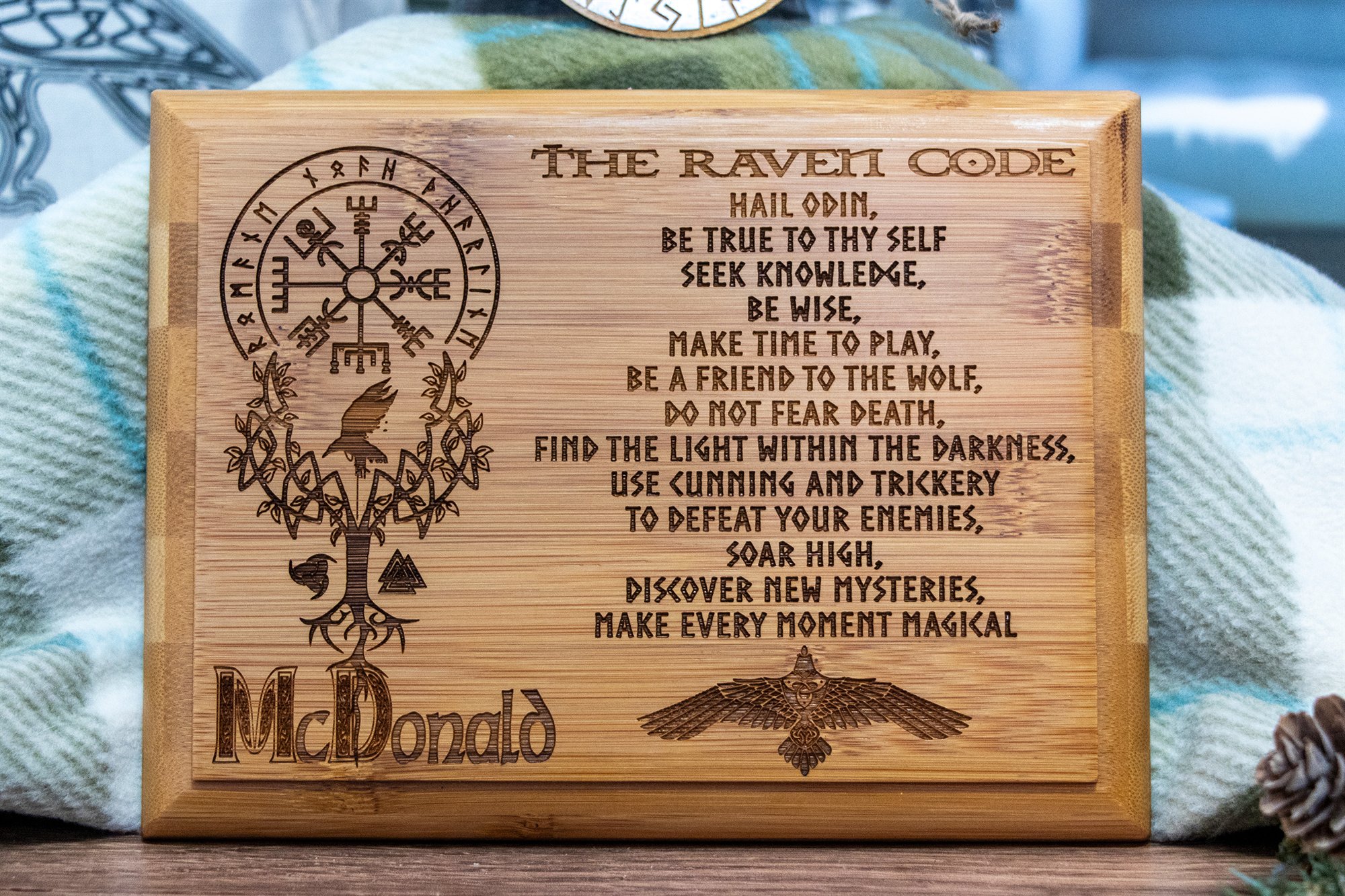 A wooden plaque engraved with the Raven Code verse, a Vegvísir compass, a tree of life and a raven, personalized with a family name